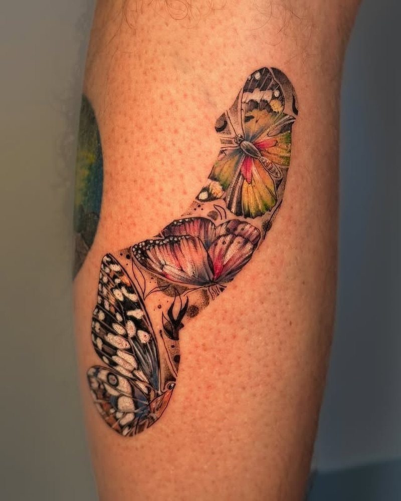 Colorful butterfly and flower tattoo on a person's leg with vibrant orange and pink hues.