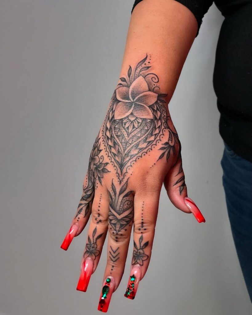 Hand with intricate black henna style tattoos and long red acrylic nails.