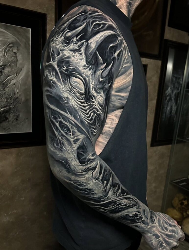Biomechanical sleeve tattoo with white ink highlights over a solid black background.